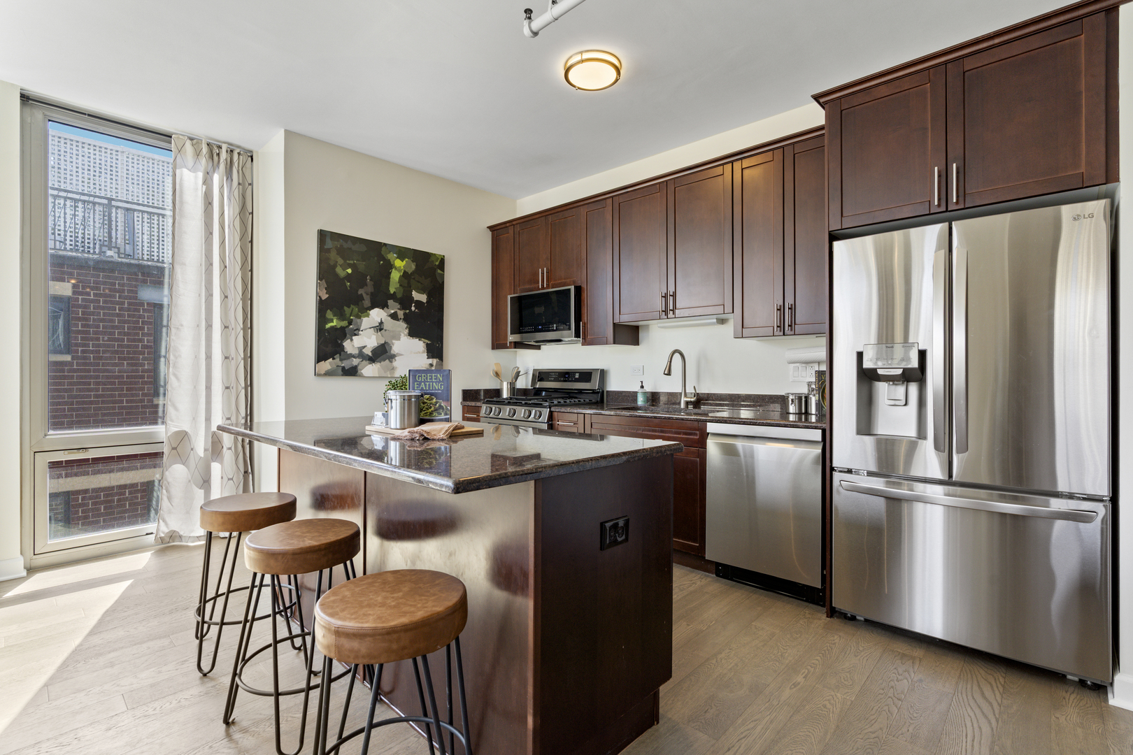 437 West Division Street, Unit 310 Chicago, IL 60610 - Photo 8 of 23 a kitchen with granite countertop a refrigerator stove and microwave