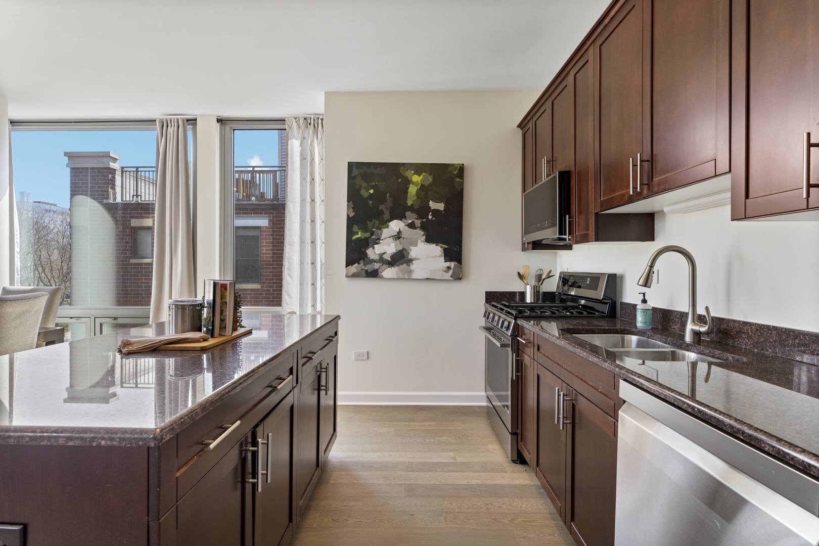 437 West Division Street, Unit 310 Chicago, IL 60610 - Photo 9 of 23 a kitchen with stainless steel appliances granite countertop a sink stove and cabinets