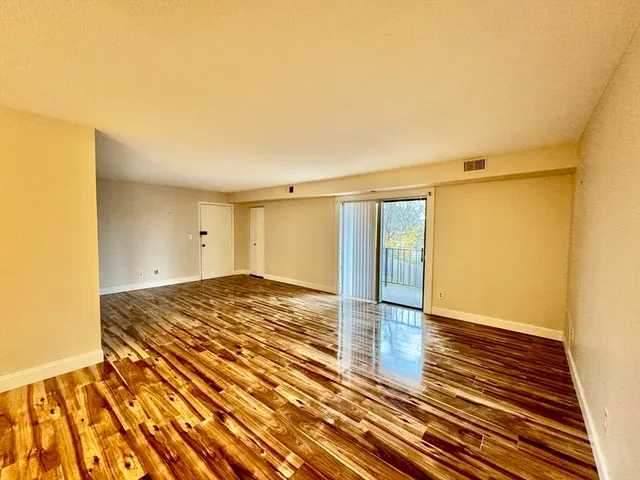 a view of an empty room and wooden floor