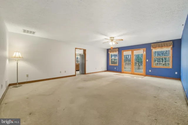 a view of an empty room with a chandelier fan