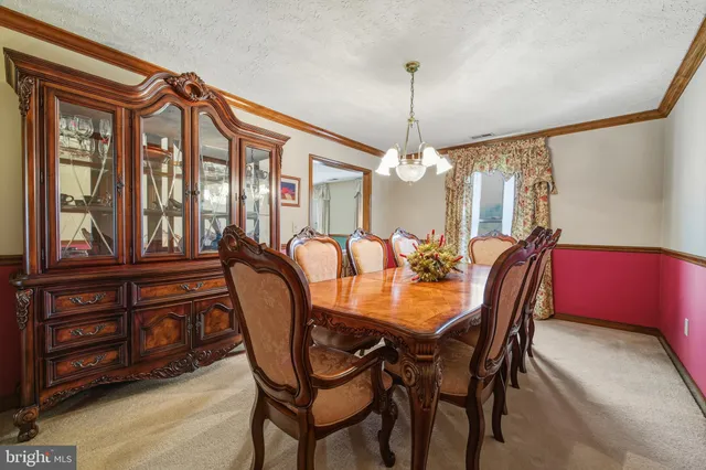an empty room with windows and chandelier fan