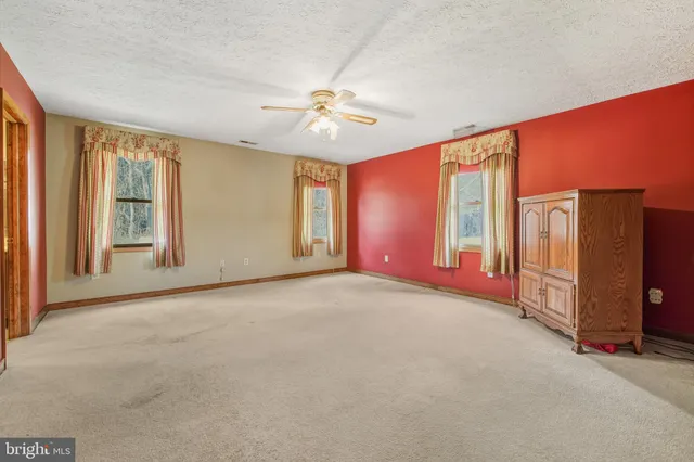 a spacious bedroom with a bed and a painting on the wall