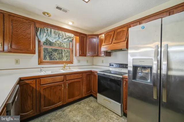 a dining room with stainless steel appliances a table chairs and chandelier