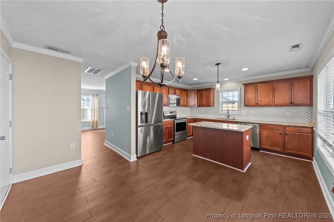 619 Cape Fear Road Raeford, NC 28376 - Photo 9 of 23 a kitchen with stainless steel appliances kitchen island granite countertop a refrigerator a stove a sink dishwasher and white cabinets with wooden floor