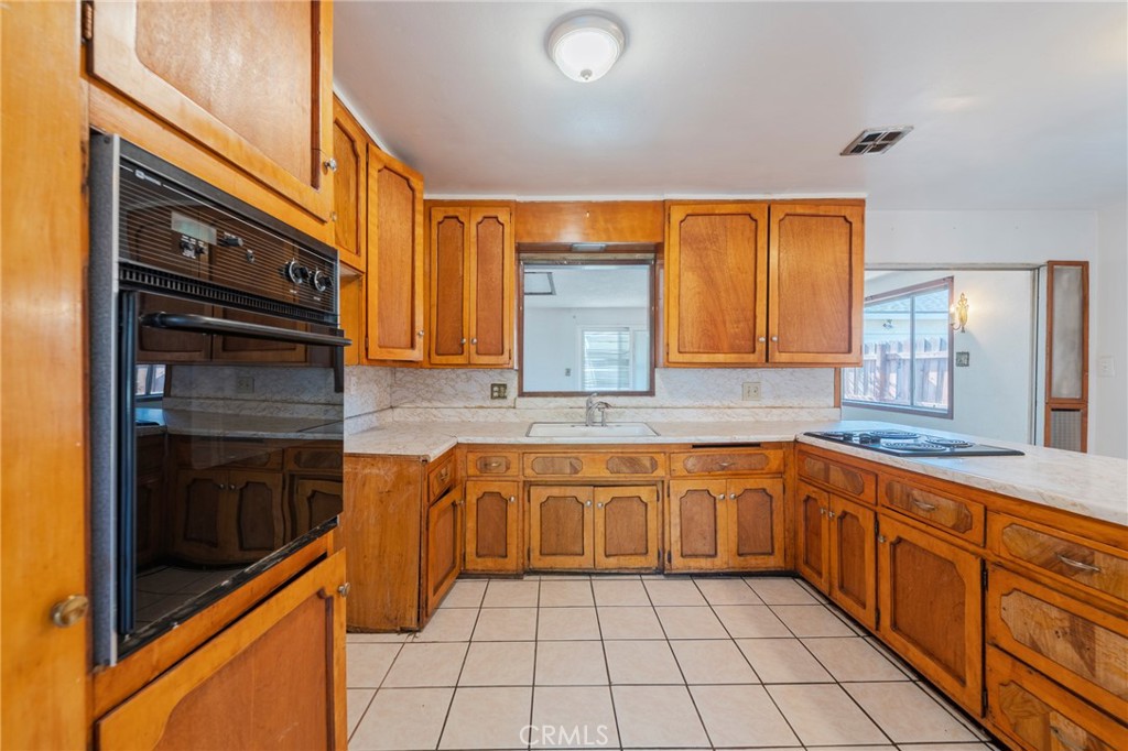 22428 Neptune Avenue Carson, CA 90745 - Photo 17 of 36 a kitchen with stainless steel appliances granite countertop a sink and cabinets