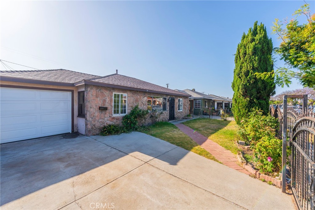 22428 Neptune Avenue Carson, CA 90745 - Photo 2 of 36 a front view of a house with a garden and outdoor seating