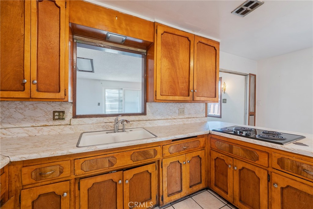 22428 Neptune Avenue Carson, CA 90745 - Photo 7 of 36 a kitchen with stainless steel appliances granite countertop a sink and cabinets with wooden floor