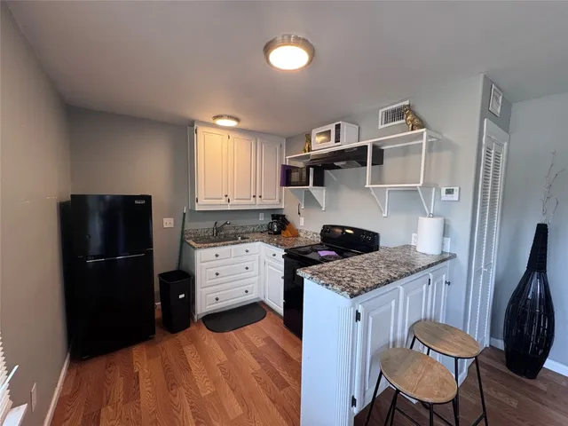 a kitchen with granite countertop a sink stove and refrigerator