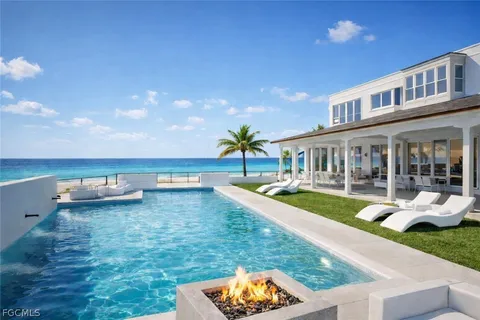 an aerial view of ocean and residential houses with outdoor space