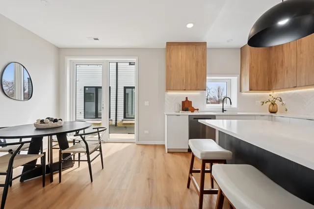 a kitchen with a table chairs sink and cabinets