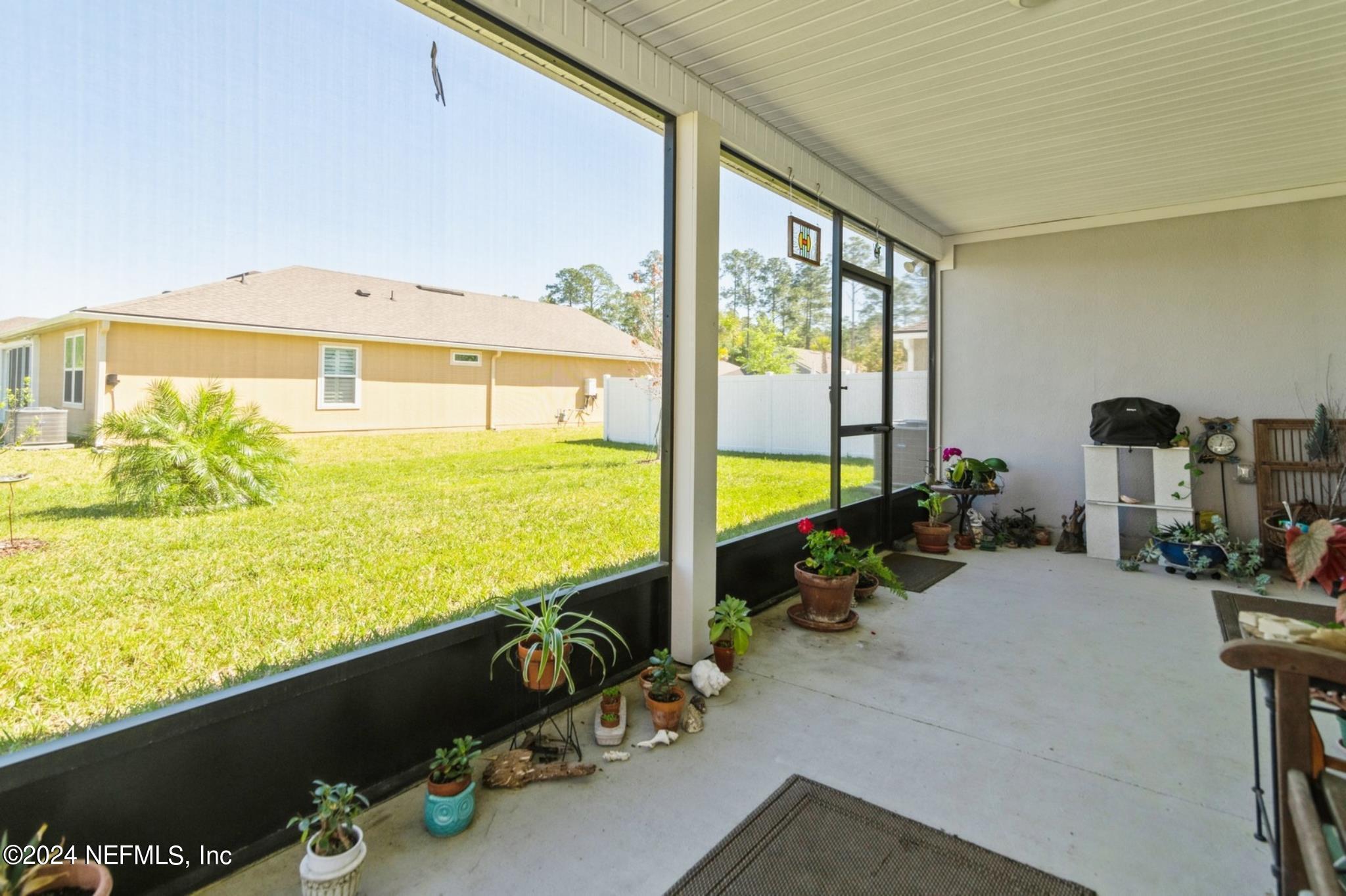 97 Spotted Owl Lane St. Augustine, FL 32095 - Photo 27 of 38 a view of a living room with floor to ceiling window next to a yard