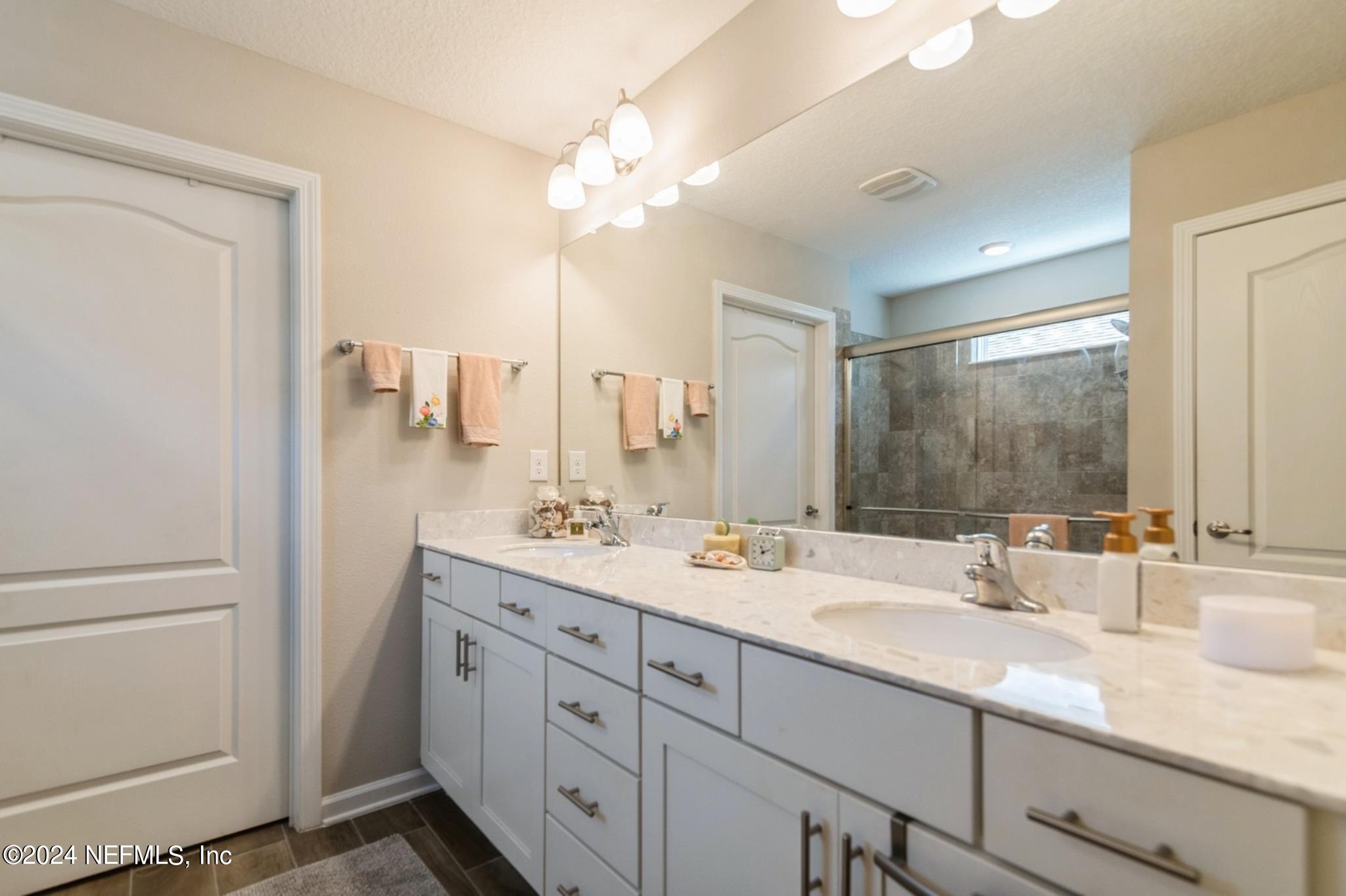 97 Spotted Owl Lane St. Augustine, FL 32095 - Photo 32 of 38 a bathroom with a double vanity sink and mirror with shower