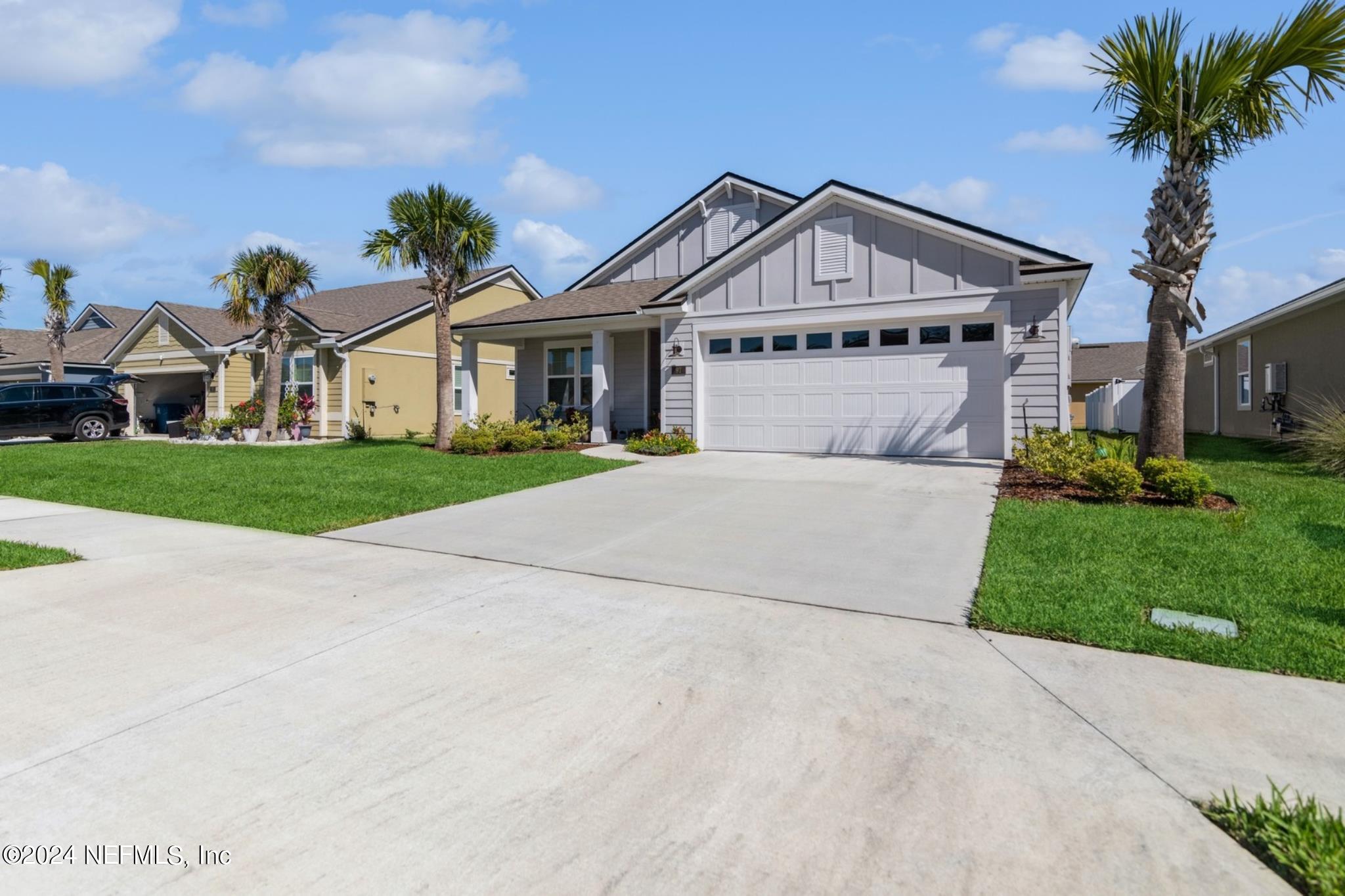 97 Spotted Owl Lane St. Augustine, FL 32095 - Photo 5 of 38 a front view of a house with a yard and garage