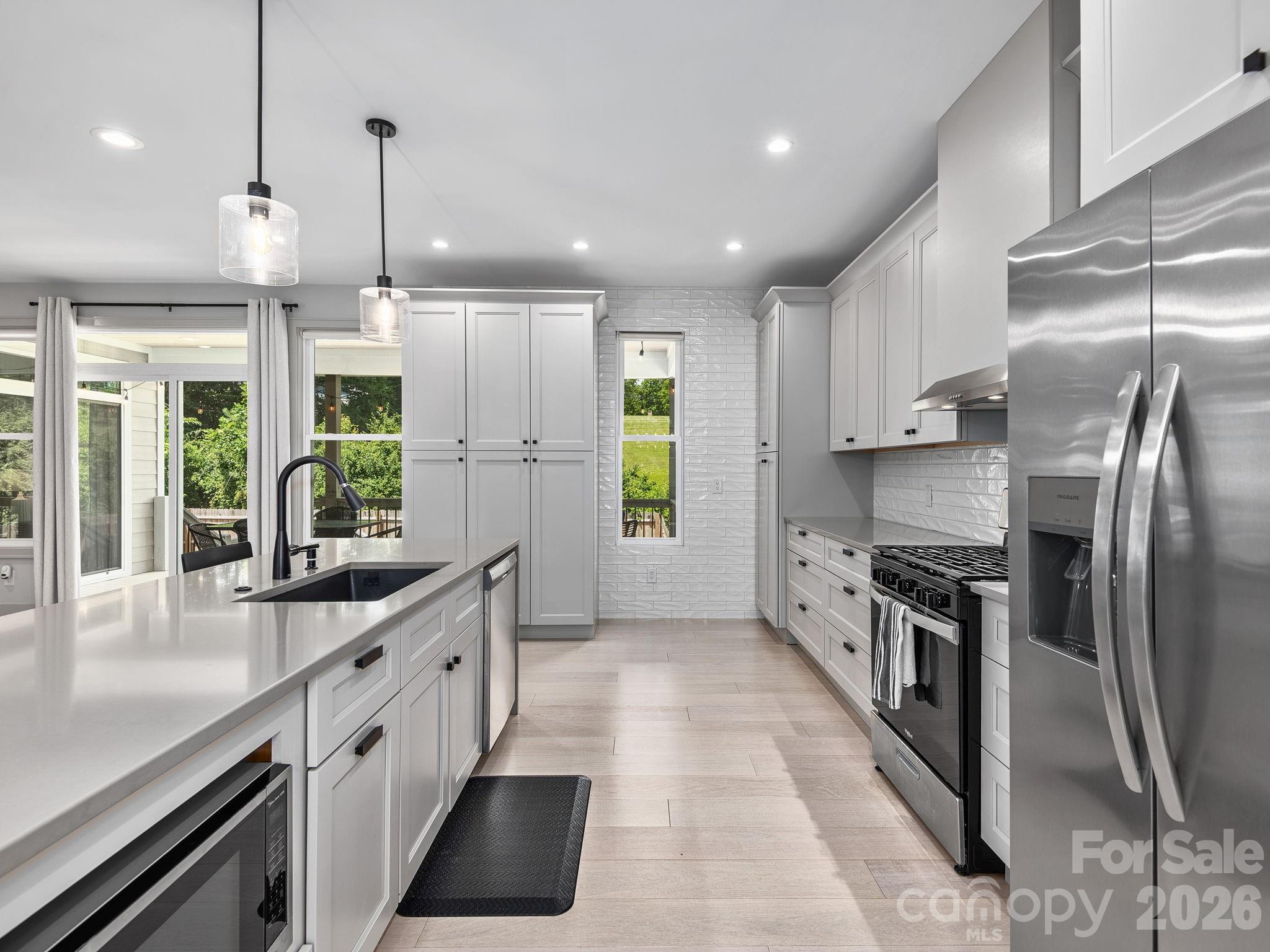 7 Copper Mill Court Candler, NC 28715 - Photo 11 of 32 a kitchen with stainless steel appliances granite countertop a stove a sink a refrigerator and a counter space