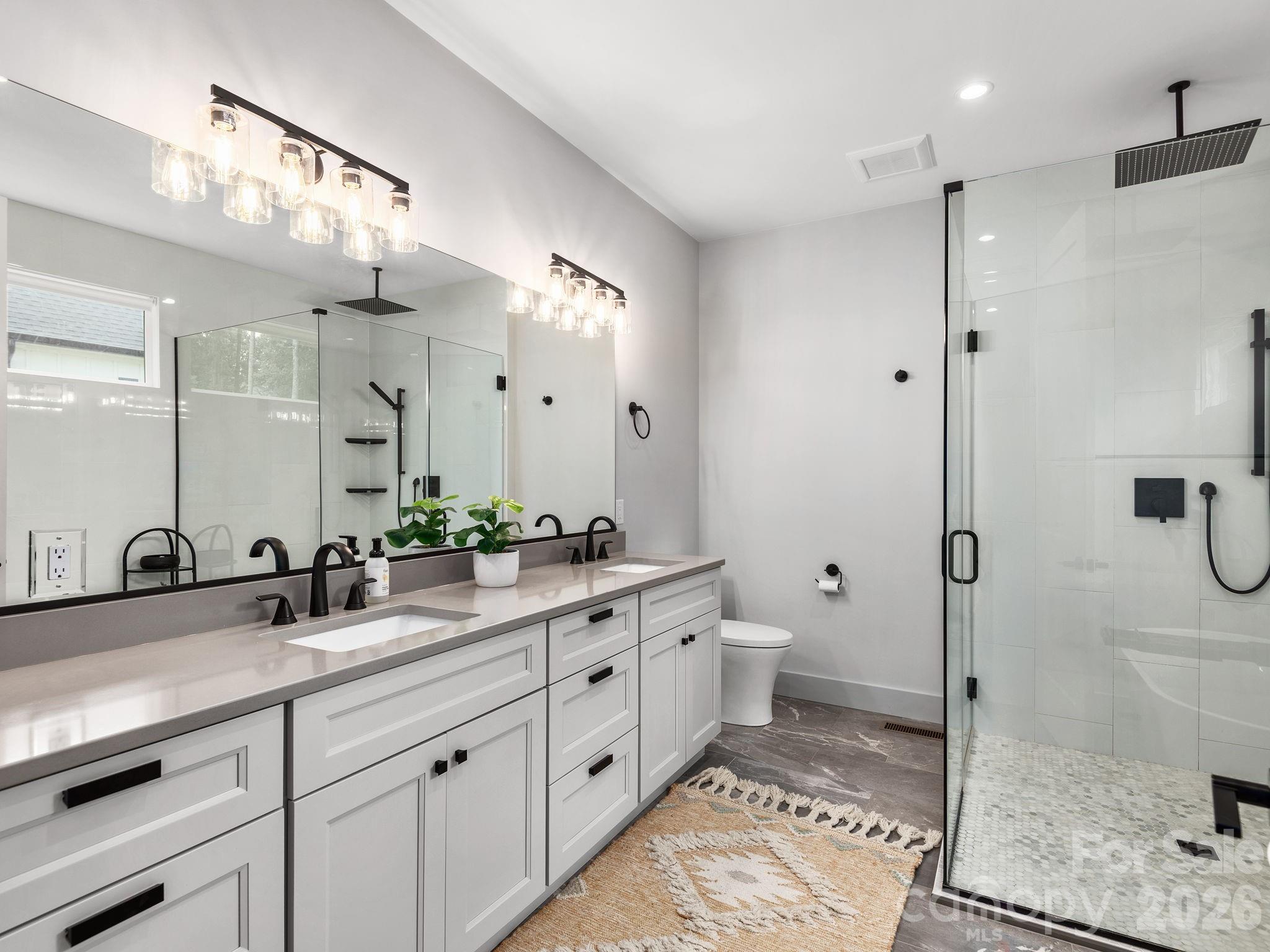 7 Copper Mill Court Candler, NC 28715 - Photo 15 of 32 a bathroom with a double vanity sink toilet and shower