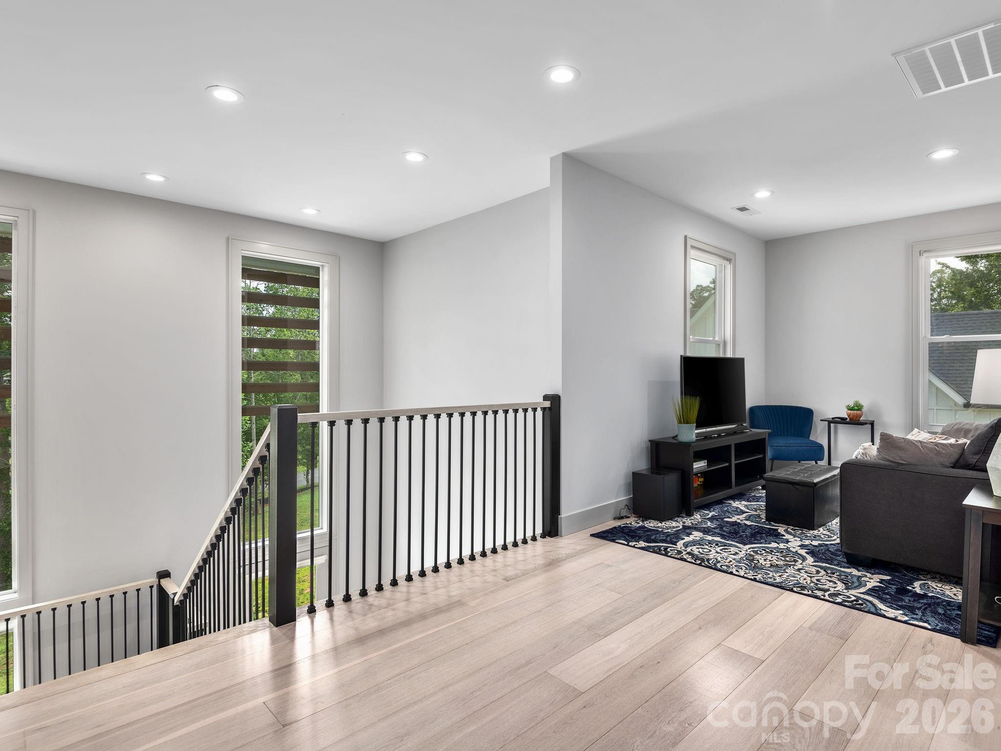 7 Copper Mill Court Candler, NC 28715 - Photo 18 of 32 a living room with furniture a flat screen tv and a wooden floor