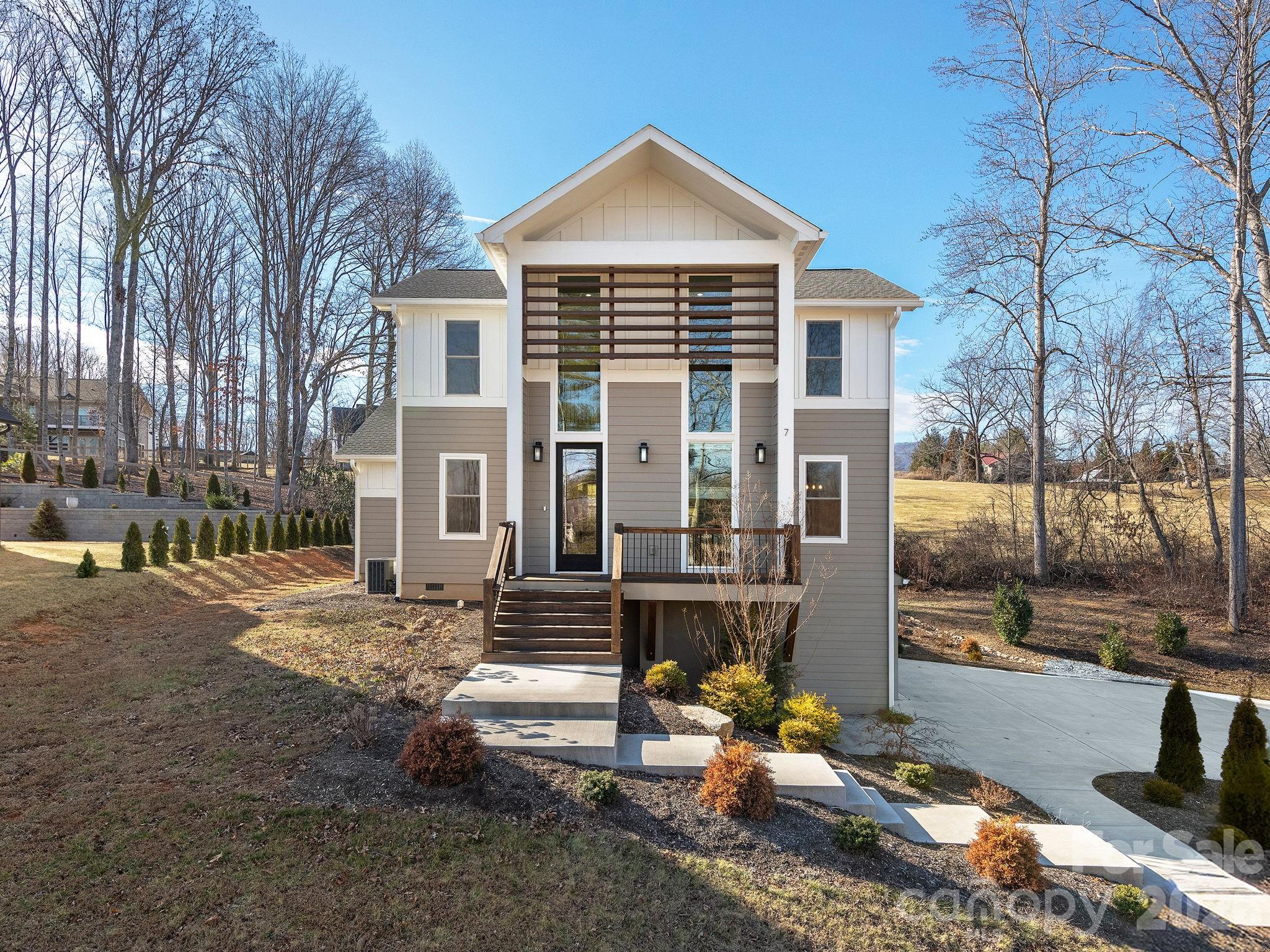 7 Copper Mill Court Candler, NC 28715 - Photo 2 of 32 a view of a brick house with many windows next to a road