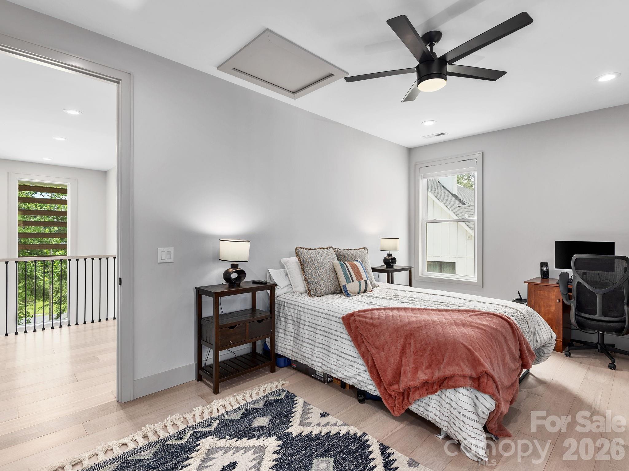 7 Copper Mill Court Candler, NC 28715 - Photo 23 of 32 a bedroom with a bed and a chandelier