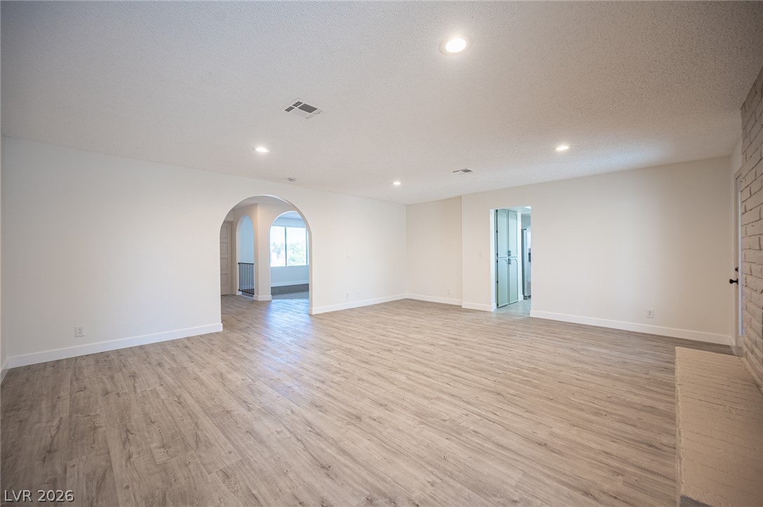 7041 North Decatur Boulevard Las Vegas, NV 89131 - Photo 13 of 33 Recessed lighting illuminates this versatile living space with light wood-look flooring and an elegant arched entryway.
