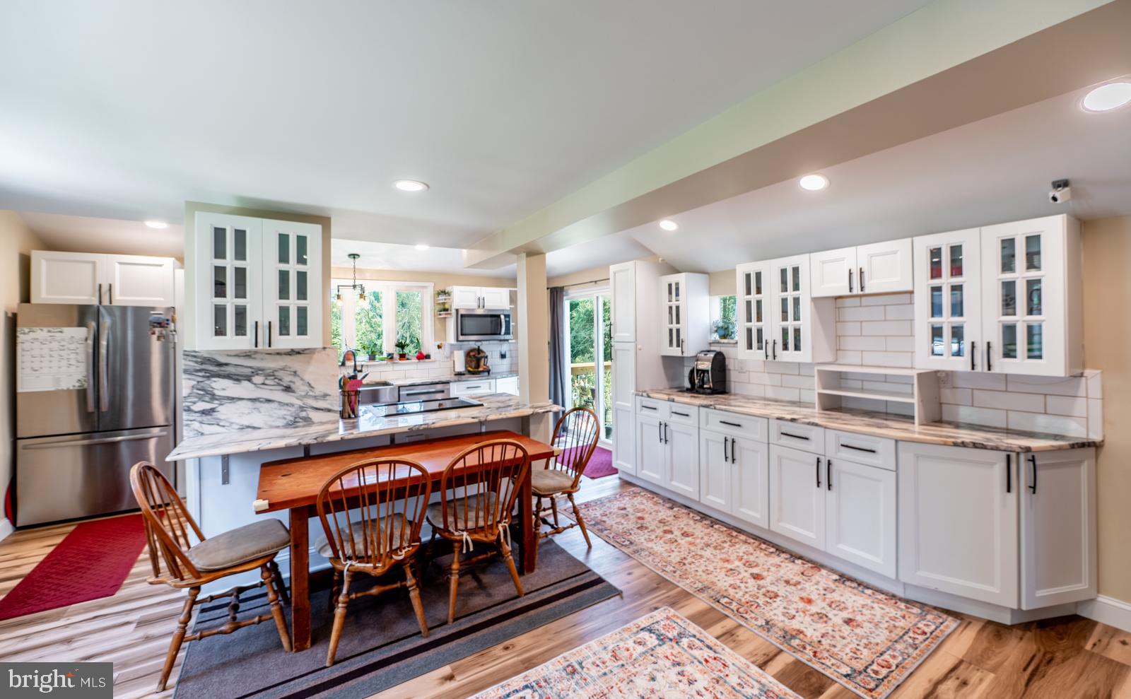 494 Baptist Church Road Spring City, PA 19475 - Photo 5 of 49 a kitchen with stainless steel appliances kitchen island granite countertop a table chairs in it and wooden floors