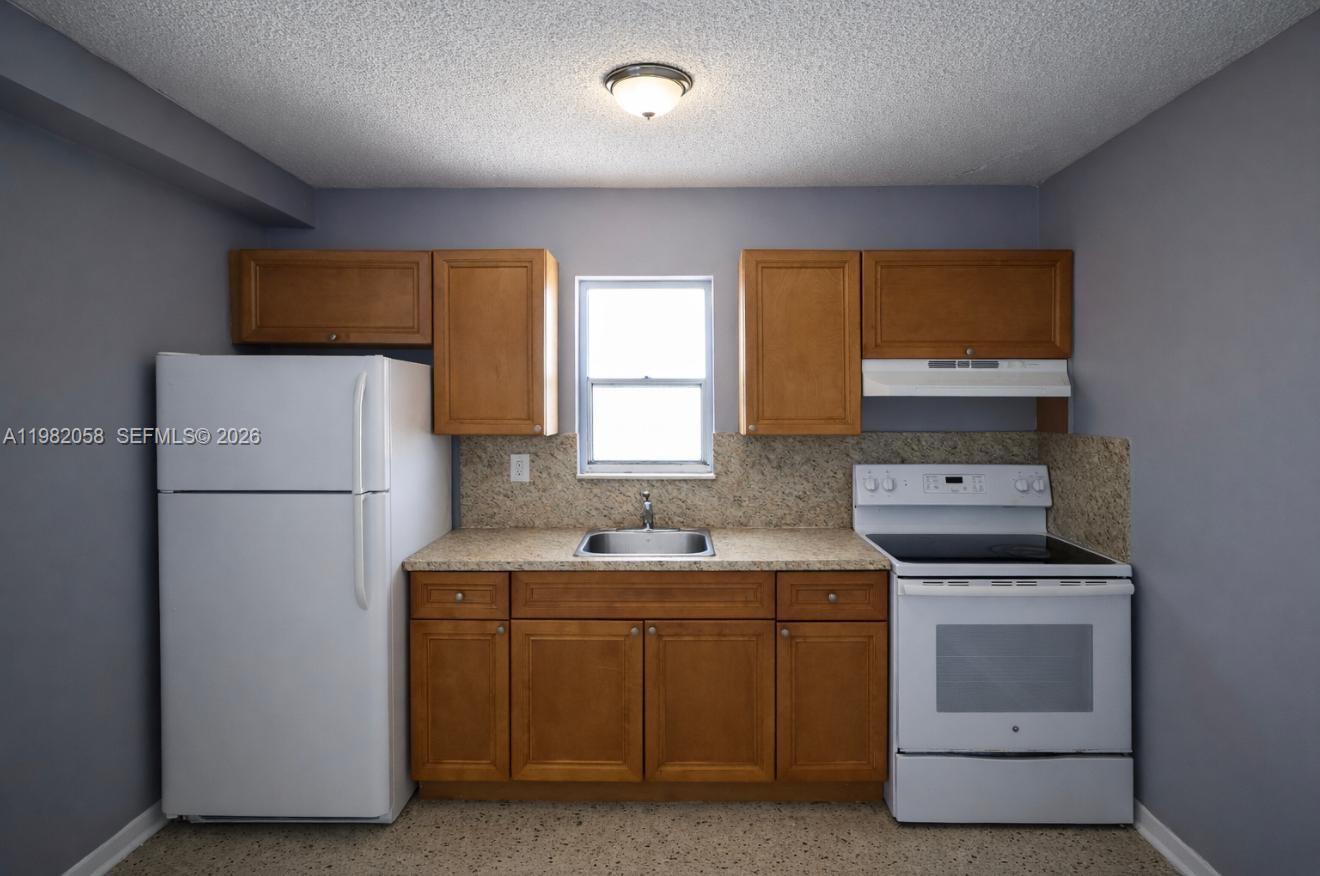 2315 West Okeechobee Road, Unit 202 Hialeah, FL 33010 - Photo 1 of 10 a utility room with cabinets washer and dryer