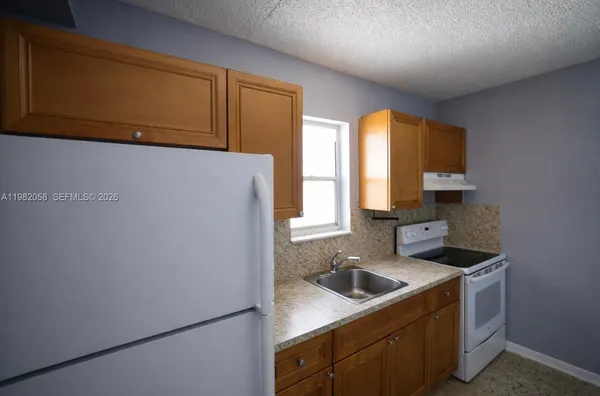 a kitchen with a sink cabinets and a refrigerator