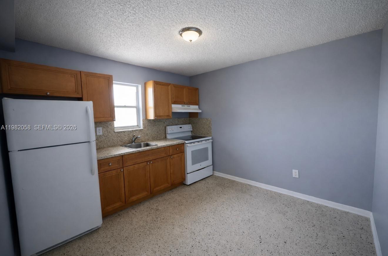 2315 West Okeechobee Road, Unit 202 Hialeah, FL 33010 - Photo 3 of 10 a kitchen with sink refrigerator and window