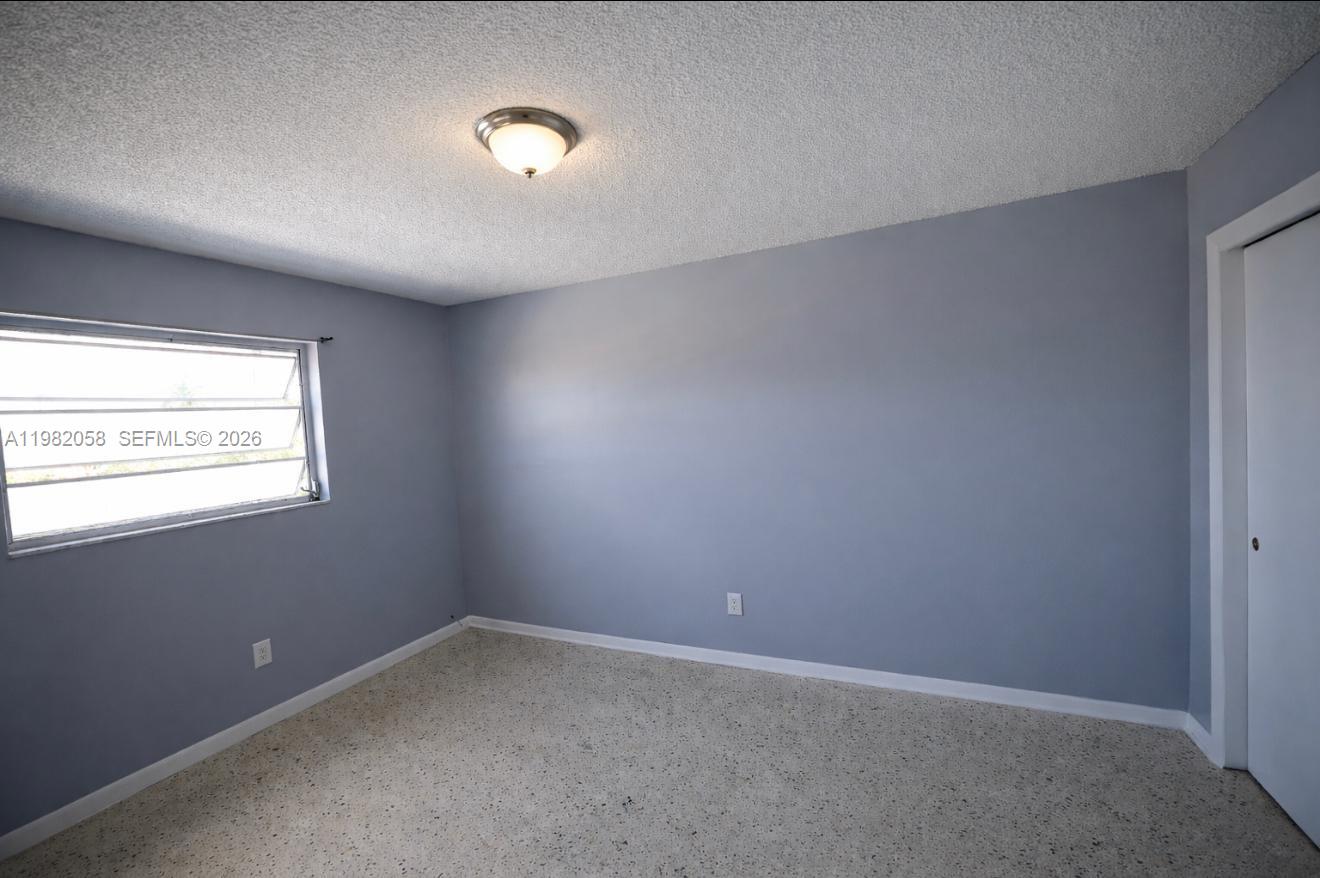 2315 West Okeechobee Road, Unit 202 Hialeah, FL 33010 - Photo 8 of 10 an empty room with windows