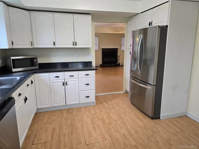 a kitchen with granite countertop white cabinets and stainless steel appliances