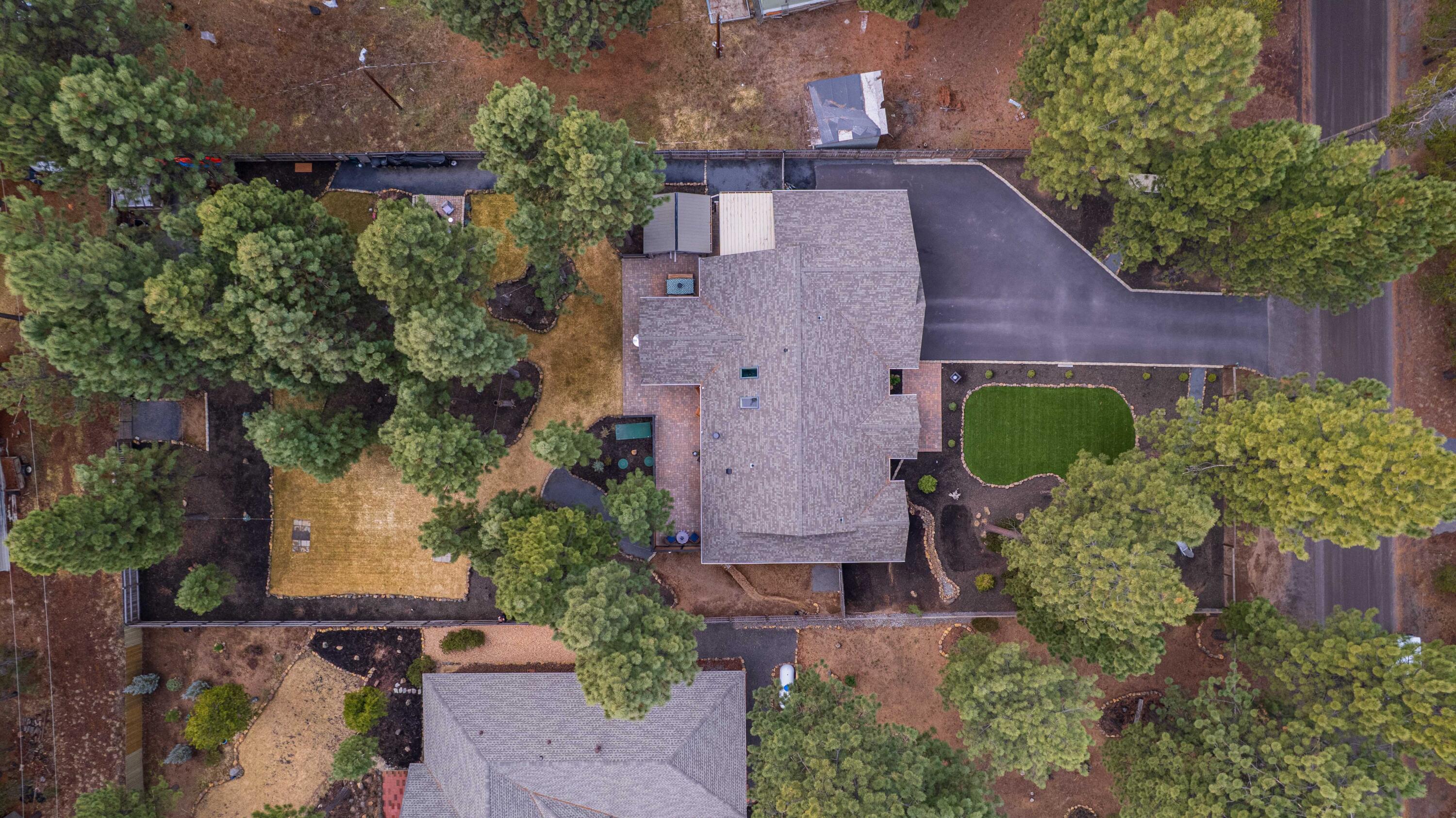 16927 Covina Road Bend, OR 97707 - Photo 50 of 54 Overhead aerial showing the full layout of the home, driveway, and beautifully developed grounds within a large, pine-filled Bend, Oregon setting.