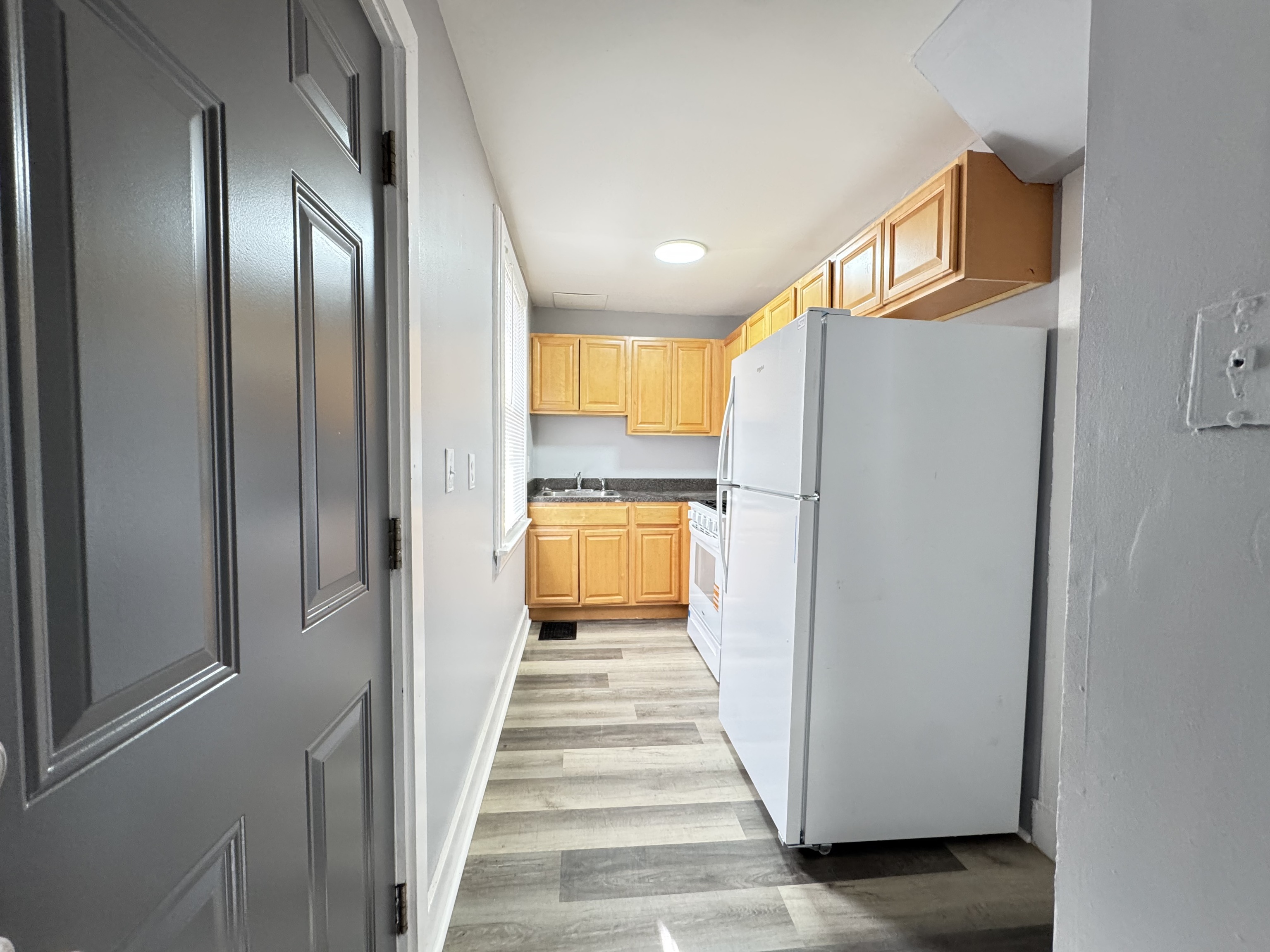 959 Winchester Avenue Hamden, CT 06517 - Photo 7 of 12 a view of a hallway with wooden floor and a kitchen