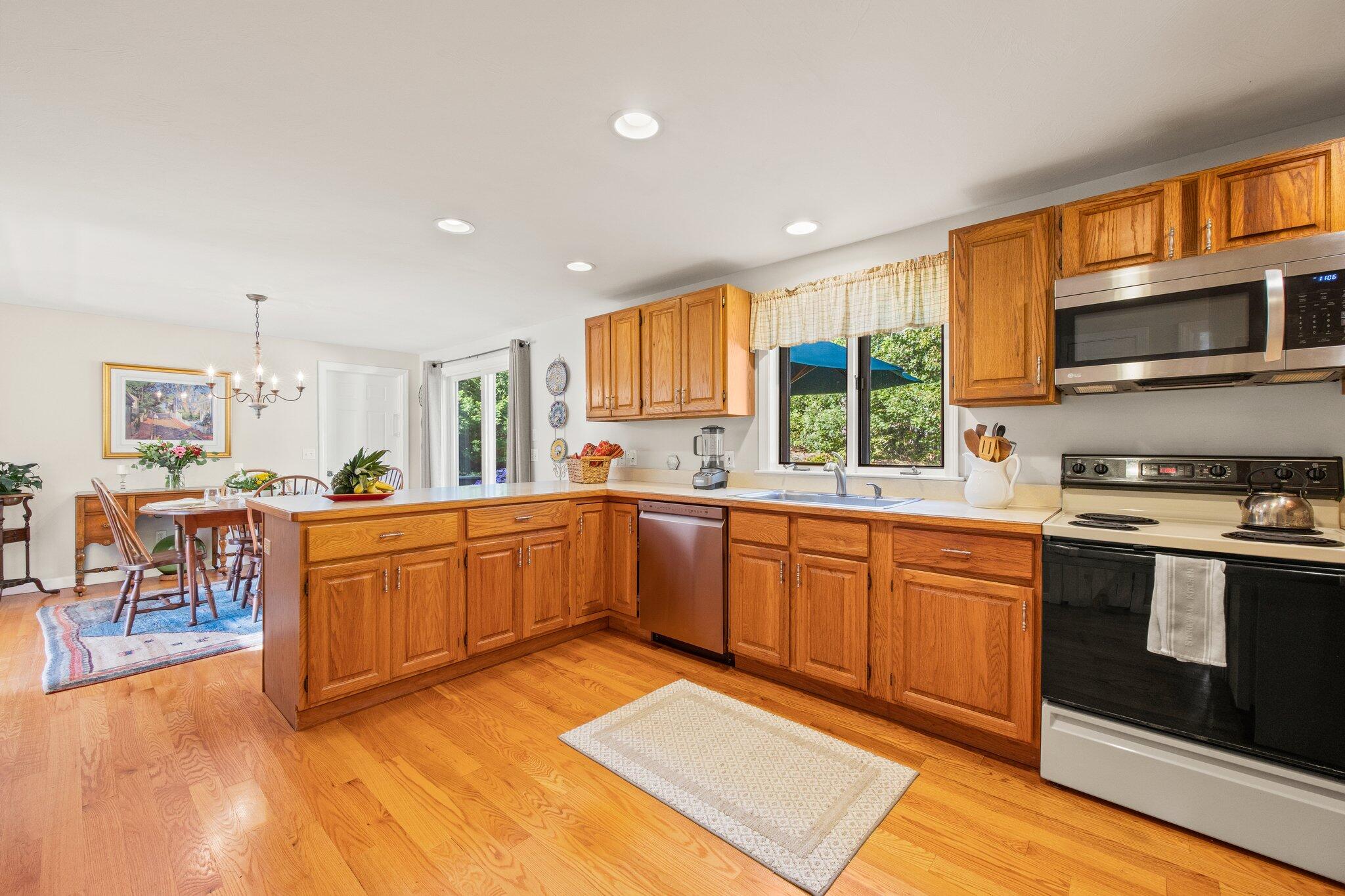 49 River Ridge Road Marstons Mills, MA 02648 - Photo 12 of 37 a large kitchen with stainless steel appliances granite countertop a stove a sink and a microwave