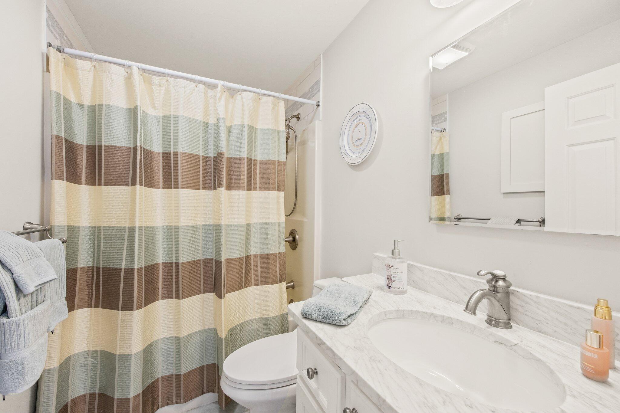 49 River Ridge Road Marstons Mills, MA 02648 - Photo 22 of 37 a bathroom with a sink a toilet a mirror and shower curtain