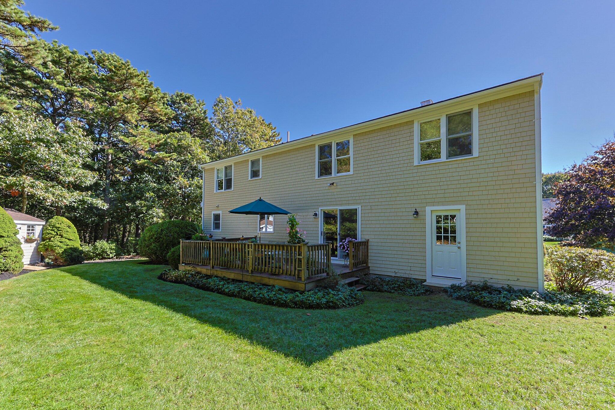 49 River Ridge Road Marstons Mills, MA 02648 - Photo 30 of 37 a front view of a house with a garden and trees