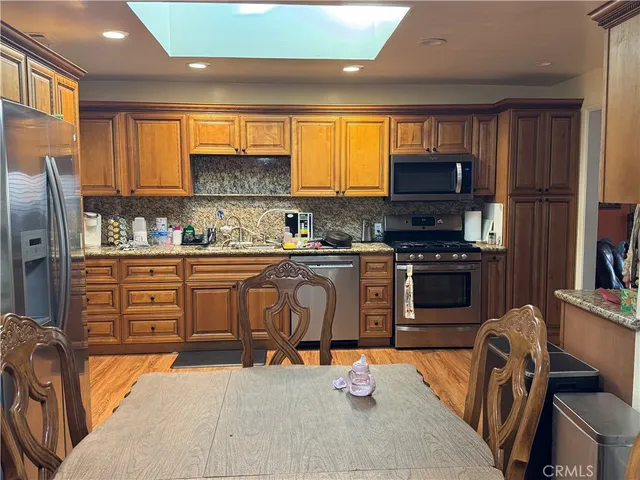 a kitchen with stainless steel appliances a stove sink microwave and refrigerator