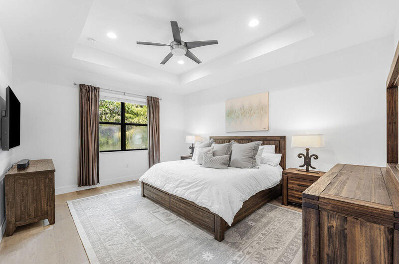 8091 Snowflake Obsidian Trail Delray Beach, FL 33446 - Photo 24 of 35 a bedroom with a large bed and a tv
