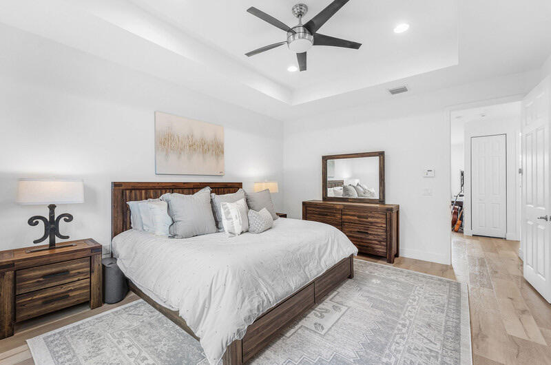 8091 Snowflake Obsidian Trail Delray Beach, FL 33446 - Photo 25 of 35 a bedroom with a bed and a chandelier