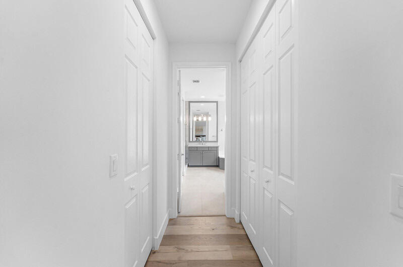 8091 Snowflake Obsidian Trail Delray Beach, FL 33446 - Photo 26 of 35 a view of a hallway with wooden floor and a bathroom