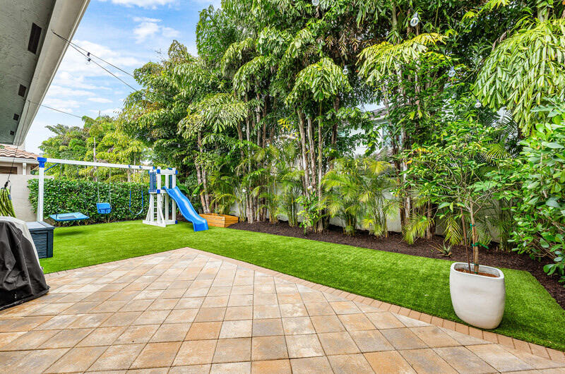 8091 Snowflake Obsidian Trail Delray Beach, FL 33446 - Photo 31 of 35 a view of a backyard with potted plants and a fountain