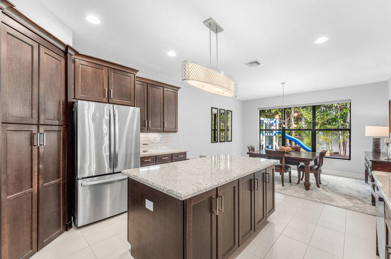 8091 Snowflake Obsidian Trail Delray Beach, FL 33446 - Photo 10 of 35 a kitchen with sink a refrigerator and chairs
