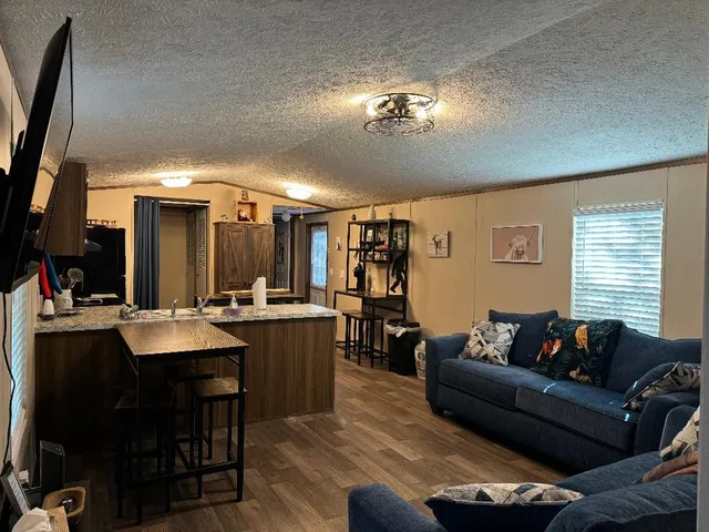a living room with furniture a chandelier and a flat screen tv