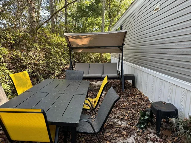 a view of a patio with table and chairs with wooden fence and plants