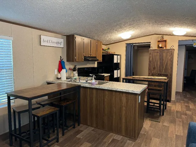a kitchen with stainless steel appliances a sink cabinets and wooden floor