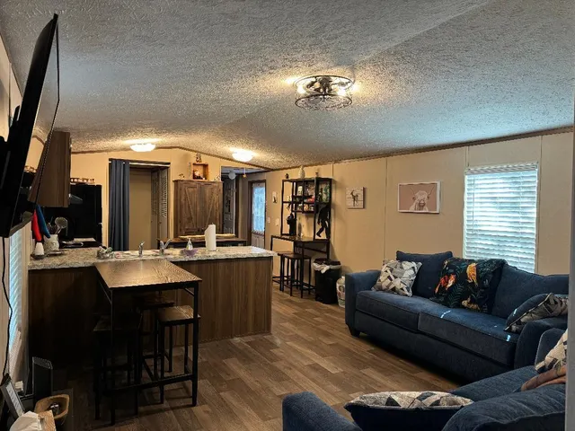 a living room with furniture a chandelier and a flat screen tv