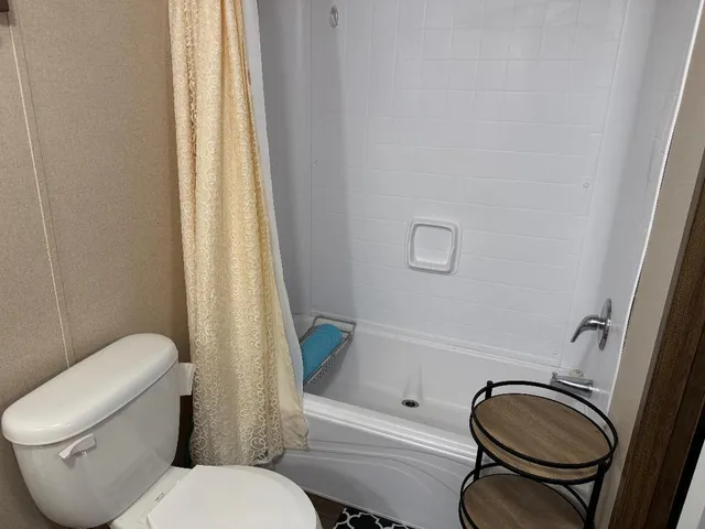 a white toilet sitting next to a bath tub