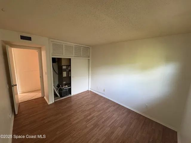 an empty room with wooden floor and closet