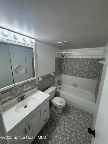 a bathroom with a sink toilet a mirror and bathtub