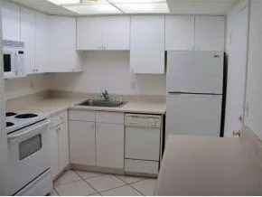 a kitchen with white cabinets and white appliances