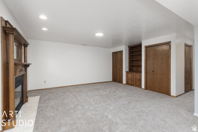 2807 North Ogden Canyon Road Eden, UT 84310 - Photo 33 of 72 Spacious room featuring light gray carpet, a fireplace with an ornate wood mantle, built-in shelving, and recessed lighting