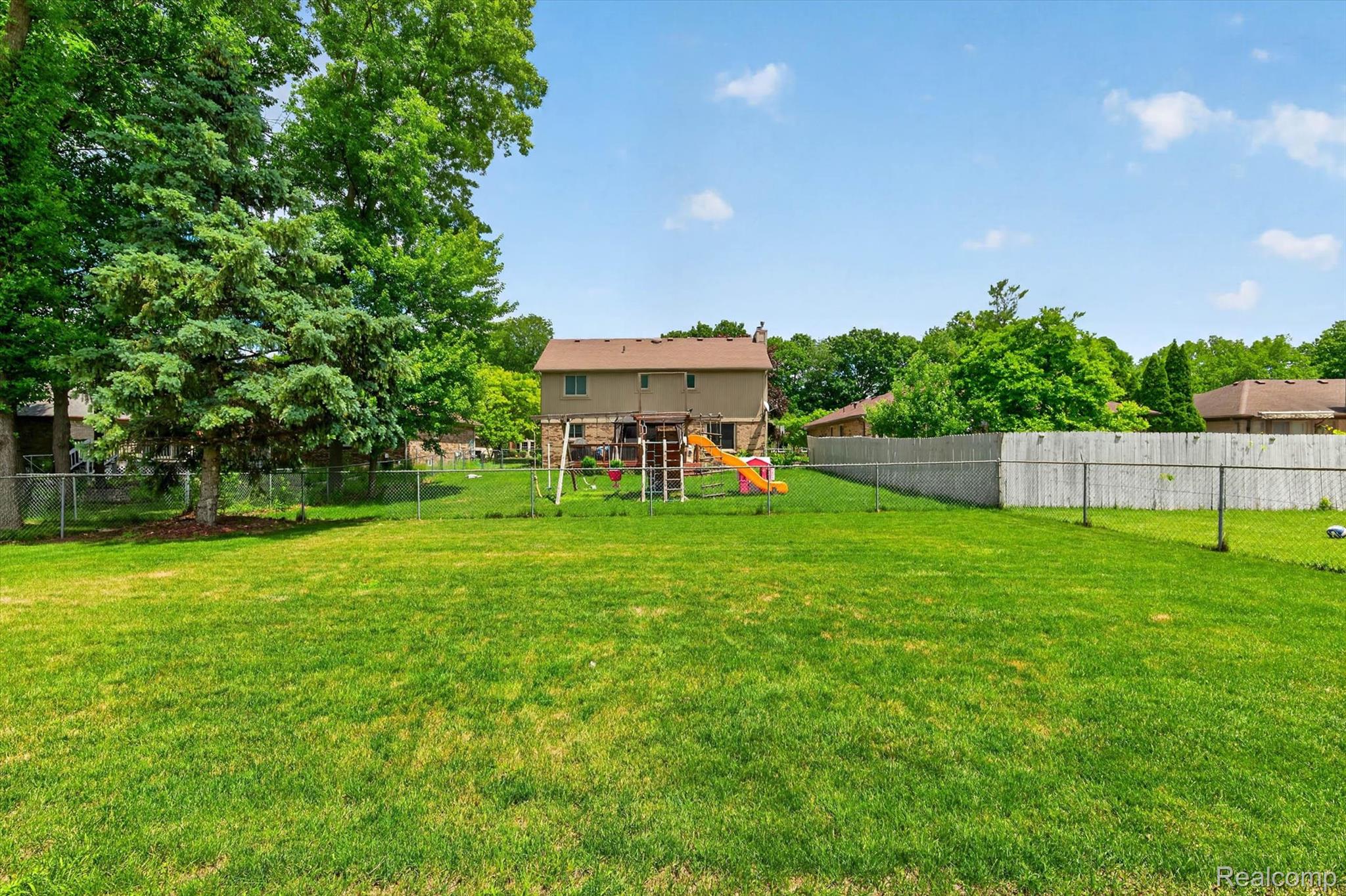 46362 Springhill Drive Utica, MI 48317 - Photo 45 of 59 Expansive lawn area featuring a chain-link fence and mature trees